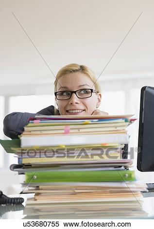 Young woman working at desk in office View Large Photo Image Stock Photography - Young woman working at desk in office. Fotosearch