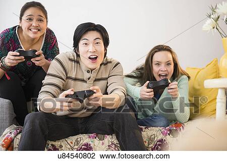 Young women and man playing video game View Large Photo Image Stock Image - Young women and man playing video game. Fotosearch
