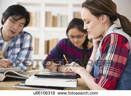 Stock Photo - Young women and man studding in library. Fotosearch