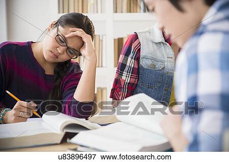 Young women and man studding in library View Large Photo Image Stock Photo - Young women and man studding in library. Fotosearch