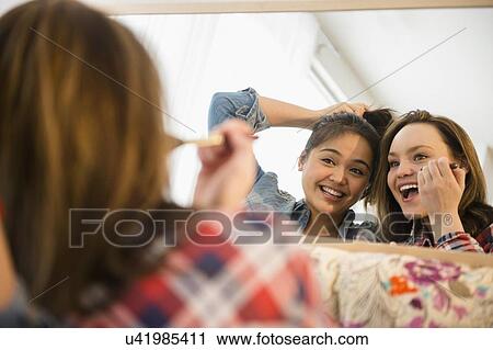 Young women doing make-up reflecting in mirror View Large Photo Image Stock Image - Young women doing make-up reflecting in mirror. Fotosearch