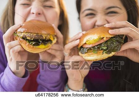 Young women eating hamburgers View Large Photo Image Stock Photograph - Young women eating hamburgers. Fotosearch