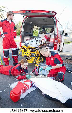 Ambulance and paramedics attending patient on road View Large Photo Image Stock Photo - Ambulance and paramedics attending patient on road. Fotosearch