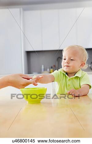 Baby boy having a snack View Large Photo Image Stock Photography - Baby boy having a snack. Fotosearch
