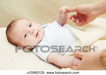 Stock Photography - Baby boy holding mother's hands. Fotosearch