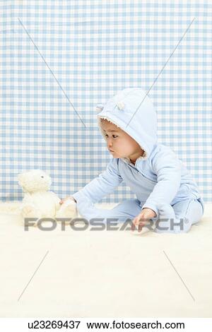 Baby boy sitting with soft toy View Large Photo Image Stock Photo - Baby boy sitting with soft toy. Fotosearch