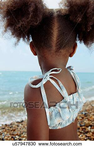 Stock Image - Backview of child looking at ocean. Fotosearch