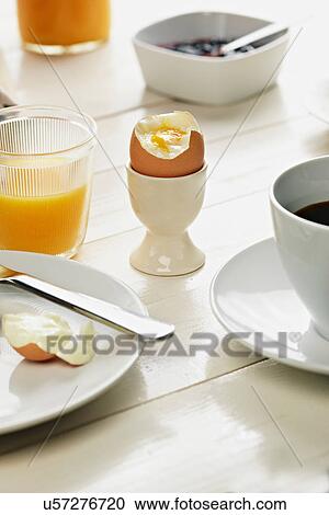 Boiled egg in egg cup at breakfast View Large Photo Image Stock Image - Boiled egg in egg cup at breakfast. Fotosearch
