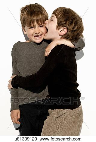 Boy biting brother's cheek View Large Photo Image Stock Image - Boy biting brother's cheek. Fotosearch
