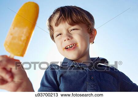 Boy eyeing his ice lolly View Large Photo Image Stock Image - Boy eyeing his ice lolly. Fotosearch