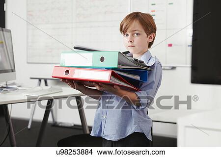 Boy holding pile of ring binders View Large Photo Image Picture - Boy holding pile of ring binders. Fotosearch