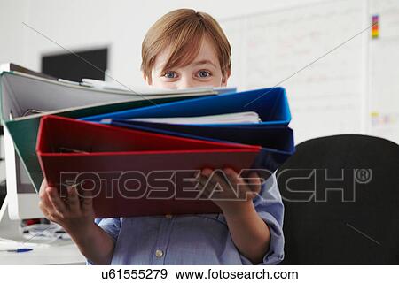 Boy holding pile of ring binders View Large Photo Image Stock Photo - Boy holding pile of ring binders. Fotosearch