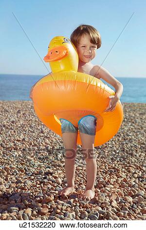 Stock Image - Boy hugging duck shaped float. Fotosearch