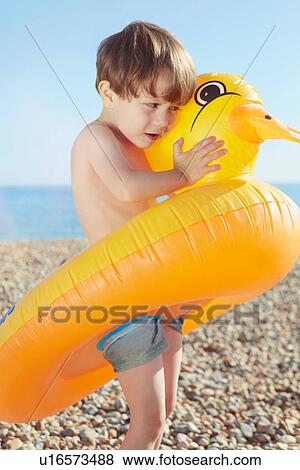 Stock Photo - Boy hugging duck shaped float. Fotosearch