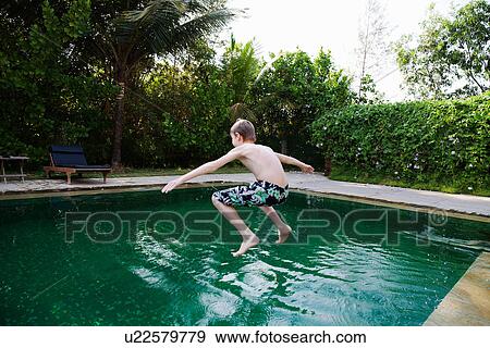 Boy jumping into swimming pool View Large Photo Image Stock Photo - Boy jumping into swimming pool. Fotosearch