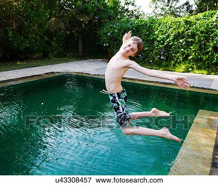 Stock Photo - Boy jumping into swimming pool. Fotosearch