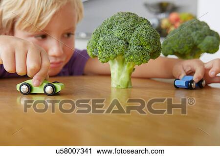 Boy playing cars around broccoli trees View Large Photo Image Stock Image - Boy playing cars around broccoli trees. Fotosearch