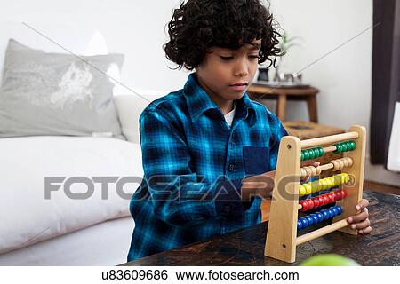 Stock Photograph - Boy playing with abacus. Fotosearch