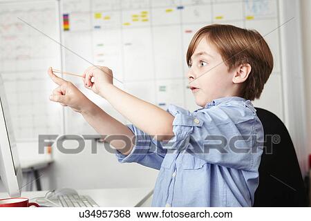 Boy playing with elastic band in office View Large Photo Image Stock Photo - Boy playing with elastic band in office. Fotosearch