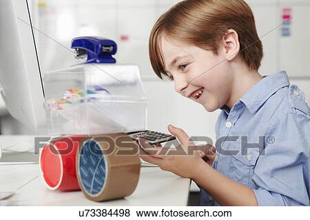 Stock Photo - Boy playing with office equipment. Fotosearch
