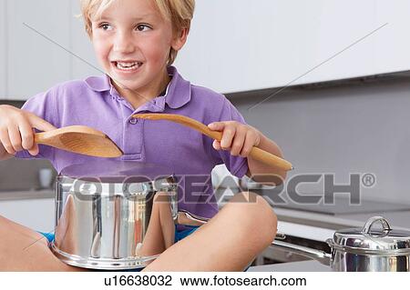 Boy sitting on kitchen counter playing drums with pans and wooden spoons View Large Photo Image Stock Image - Boy sitting on kitchen counter playing drums with pans and wooden spoons. Fotosearch