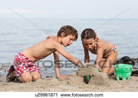 Brother and sister on beach building sandcastle View Large Photo Image Stock Image - Brother and sister on beach building sandcastle. Fotosearch