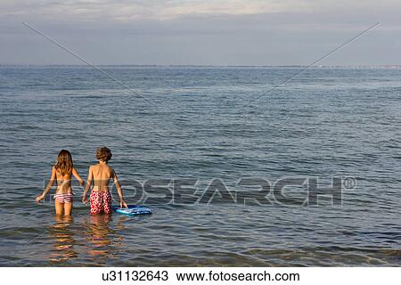 Brother and sister paddling in sea View Large Photo Image Stock Image - Brother and sister paddling in sea. Fotosearch