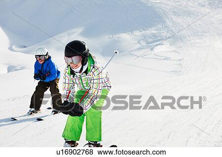 Brother and sister skiing downhill, Les Arcs, Haute-Savoie, France View Large Photo Image Stock Photo - Brother and sister skiing downhill, Les Arcs, Haute-Savoie, France. Fotosearch