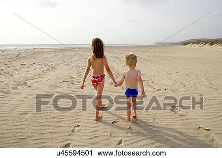 Brother and sister walking on beach holding hands View Large Photo Image Stock Image - Brother and sister walking on beach holding hands. Fotosearch