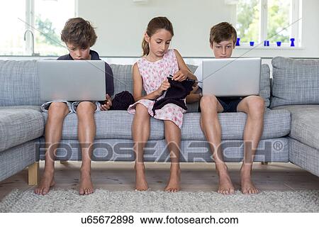 Brothers and sister on sofa with computers and knitting View Large Photo Image Stock Photo - Brothers and sister on sofa with computers and knitting. Fotosearch