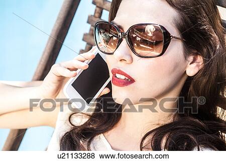 Brunette woman on cell phone wearing sunglasses View Large Photo Image Stock Photo - Brunette woman on cell phone wearing sunglasses. Fotosearch