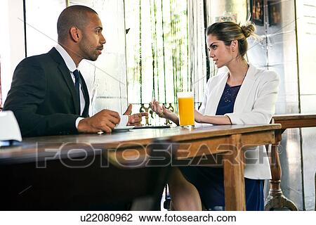 Stock Image - Business man and woman in cafe. Fotosearch