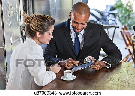 Stock Image - Business man and woman in cafe with digital tablet. Fotosearch