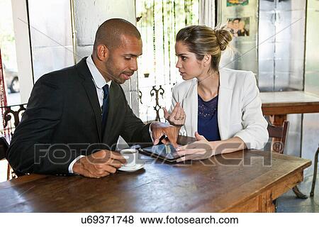Stock Photo - Business man and woman in cafe with digital tablet. Fotosearch