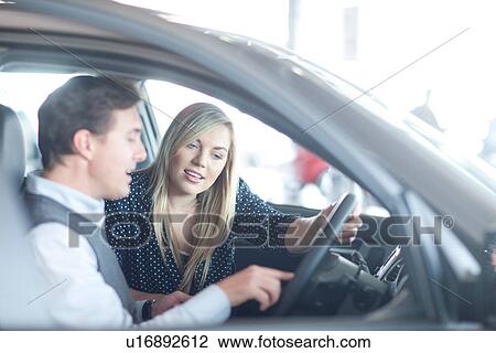 Car salesman advising young woman in car showroom View Large Photo Image Stock Image - Car salesman advising young woman in car showroom. Fotosearch