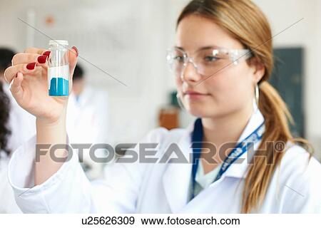 Chemistry student holding blue chemical View Large Photo Image Stock Photo - Chemistry student holding blue chemical. Fotosearch