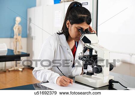 Stock Photo - Chemistry student using microscope in laboratory. Fotosearch