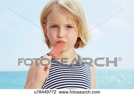 Stock Image - Child eating ice lolly. Fotosearch