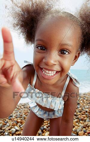 Picture - Child posing for camera at beach. Fotosearch