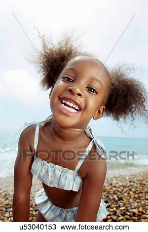 Stock Image - Child posing for camera at beach. Fotosearch