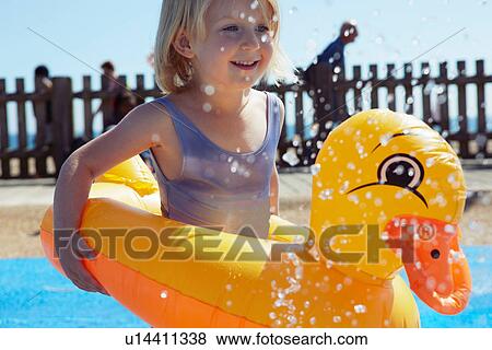Stock Photo - Child with duck-shaped float in pool. Fotosearch