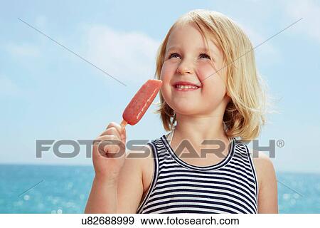 Stock Photo - Child with ice lolly looking up. Fotosearch