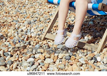 Child with plastic sandals on beach deck chair View Large Photo Image Stock Image - Child with plastic sandals on beach deck chair. Fotosearch