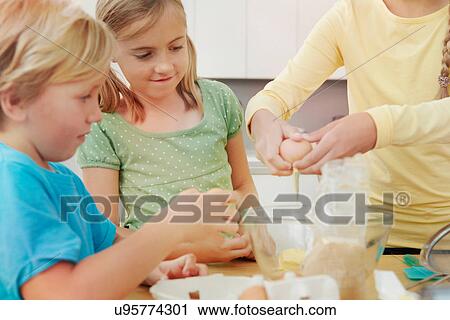 Children baking, breaking eggs into bowl View Large Photo Image Stock Image - Children baking, breaking eggs into bowl. Fotosearch