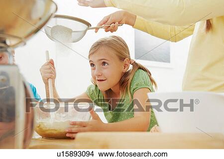 Children baking, sieving flour into mixing bowl View Large Photo Image Picture - Children baking, sieving flour into mixing bowl. Fotosearch