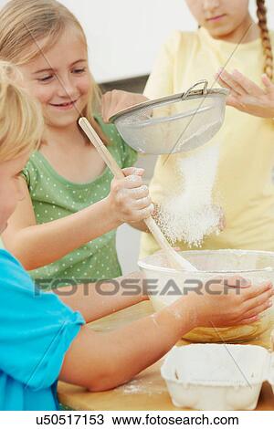 Children baking, sieving flour into mixing bowl View Large Photo Image Stock Image - Children baking, sieving flour into mixing bowl. Fotosearch