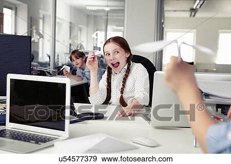 Stock Photo - Children holding paper airplanes in office. Fotosearch