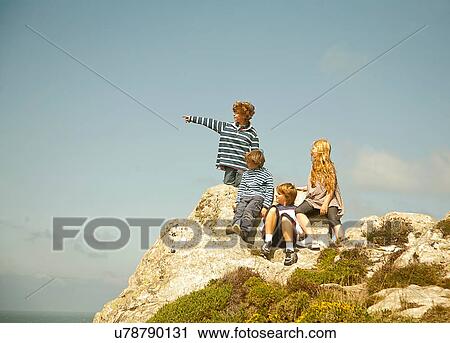 Children sitting on rocks View Large Photo Image Stock Image - Children sitting on rocks. Fotosearch