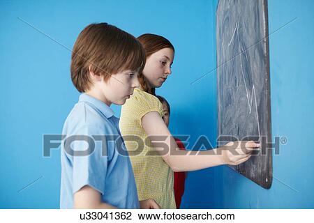Children writing on blackboard, blue background View Large Photo Image Stock Image - Children writing on blackboard, blue background. Fotosearch