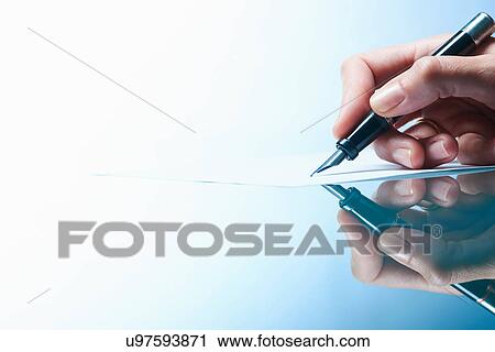 Stock Image - Close up of female hand writing on paper with ink pen. Fotosearch